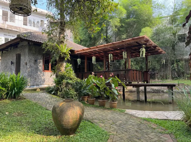 Villa Lavender with wooden terrace, pond, and garden setting at Rumah Gadog Bogor